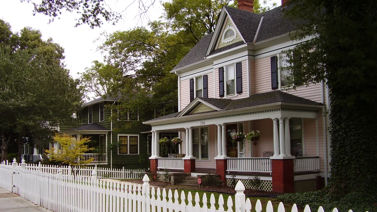 A street of older single-family homes behind a white picket fence in the Aycock neighbourhood of Greensboro, North Carolina